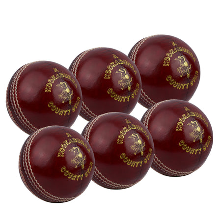 The Kookaburra County Star Red 6 Pack cricket balls, with white stitching and gold branding, are displayed in two rows against a crisp white background.