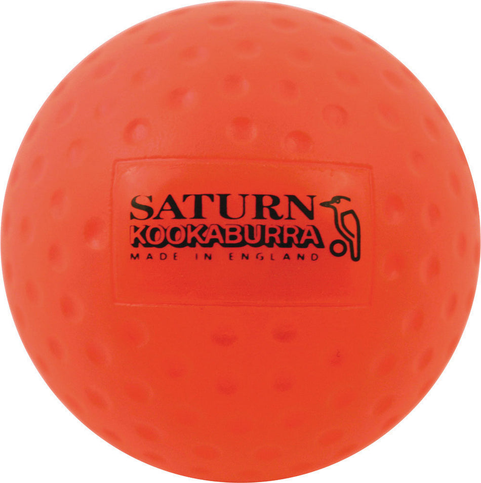 The orange Kookaburra Dimple Saturn Hockey Ball, featuring "SATURN KOOKABURRA MADE IN ENGLAND" and a black bird graphic, is ideal for school hockey or training.