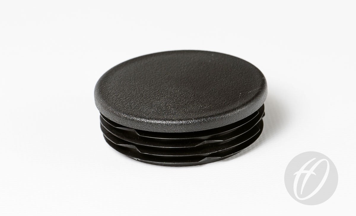 The Harrod Sport Plastic Lids for 63.5mm round sockets, featuring a black, textured top and ribbed sides, are shown on a white background—ideal as drop-in caps for rugby post lids.