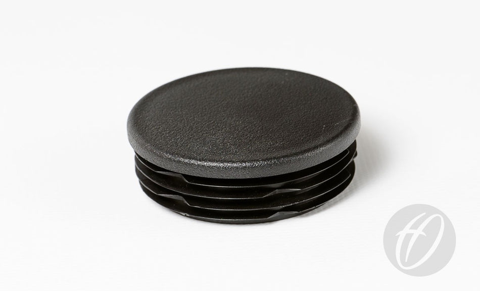 The Harrod Sport Plastic Lids for 63.5mm round sockets, featuring a black, textured top and ribbed sides, are shown on a white background—ideal as drop-in caps for rugby post lids.