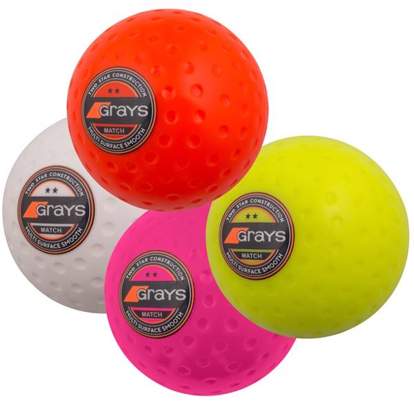 A box of 60 Grays Match Hockey Balls features orange, yellow, white, and pink balls with a club-level dimpled pattern and Grays logo, all shown together against a white background.