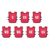 The Precision Training Mesh Netball Training Bibs pack includes 7 red bibs with white position letters (C, GS, GD, WD, WA, GK, GA) and black side straps for secure fit during play.