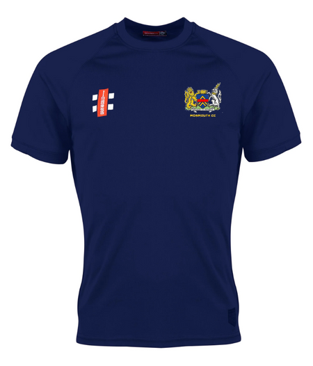 The Gray Nicolls Monmouth CC Matrix V2 Tee Shirt Senior is a navy short-sleeve sports shirt with a lion and unicorn crest on the left chest and a white/red rectangular logo on the right, made from moisture-wicking fabric.