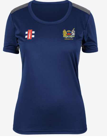 The Gray Nicolls Monmouth CC Pro Performance Short Sleeve Women's T-Shirt is blue with grey shoulder panels, a small white and red logo on the left chest, and a colorful Monmouth CC crest on the right—ideal for club training sessions.