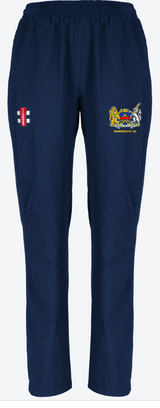 The Monmouth CC Velocity Track Trousers Women's by Gray Nicolls are navy blue with an elastic waistband and two embroidered logos: a red and white flag on the left thigh and a yellow crest with "MONMOUTH CC" on the right.