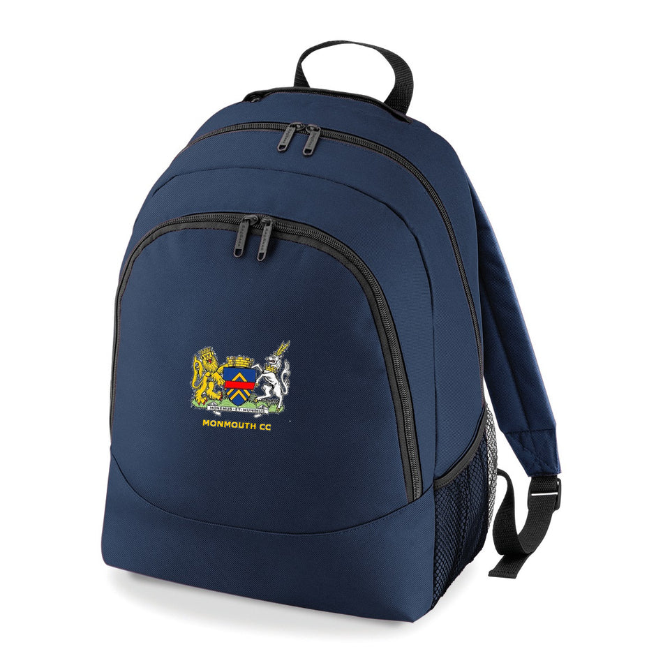 The PenCarrie Monmouth CC BG212 Universal Backpack is navy blue, made from durable 600D polyester with black zippers, mesh side pockets, an embroidered crest, and "MONMOUTH CC" on the front pocket.