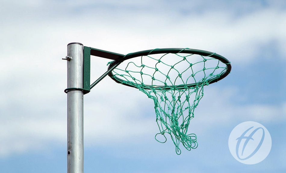 A close-up of Harrod Sport Regulation Netball Rings - 16mm (Pair), featuring a green net and durable tubular steel, set outdoors against a blue sky with light clouds.