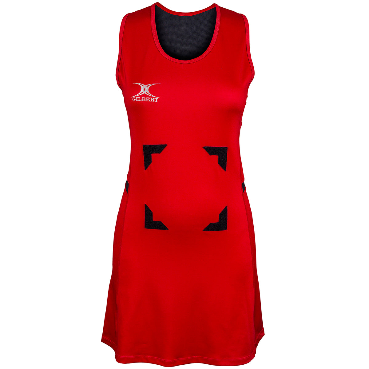 The Gilbert Synergie Netball Dress is a sleeveless red dress featuring black trim at the neckline, a white Gilbert logo on the left chest, and four black rectangular patches arranged in a square on the front.