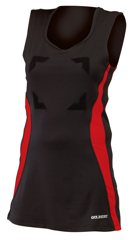 The Gilbert Eclipse Netball Dress by Gilbert features a sleeveless black/red design with red side panels, scoop neckline, four rectangular black velcro patches on the front, and the GILBERT logo near the hem.