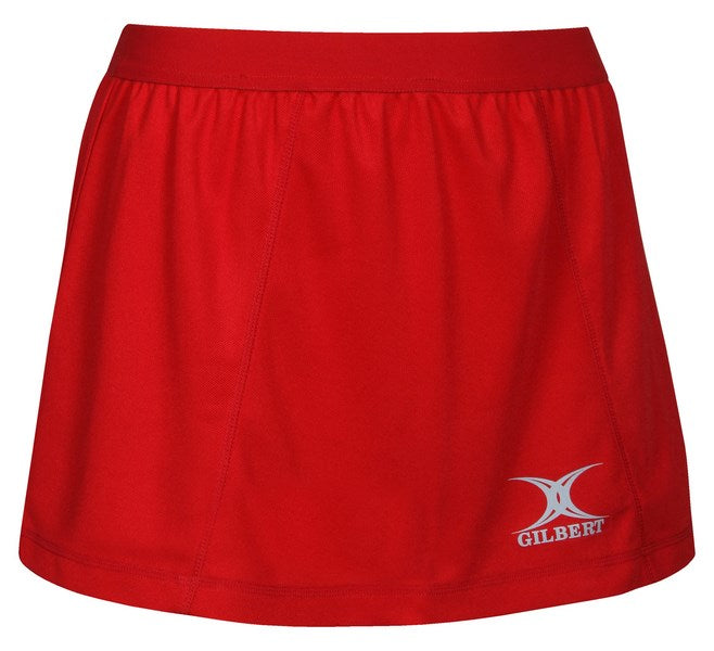 The Gilbert Blaze Netball Skirt is a plain red sports skirt with an elastic waistband and a white Gilbert logo near the hem, combining comfort and style for active days.