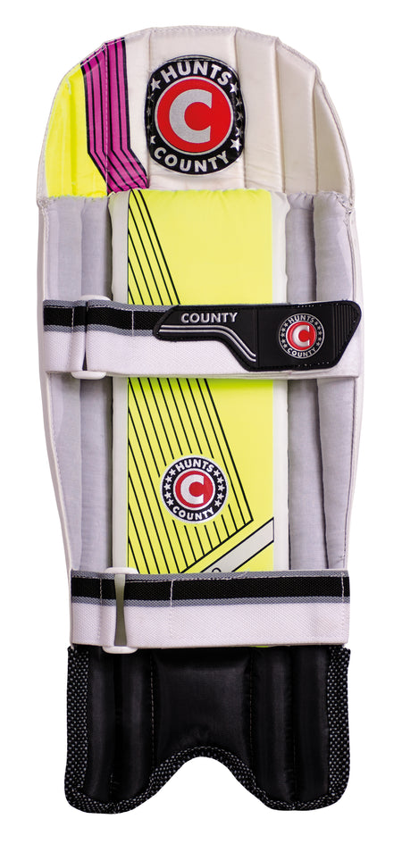 The Hunts County Neo Wicket Keeping Pad features white, yellow, black, and pink accents, protective cane padding, the Hunts County logo, and two black straps—an essential for cricket wicket keepers.