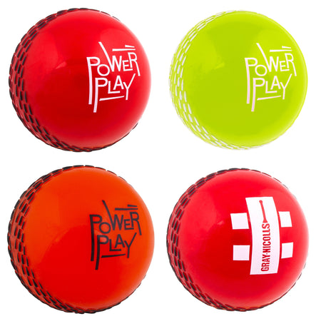 Four vibrant Gray Nicolls PowerPlay Balls—red, yellow, orange, and a red one with a white Gray Nicolls logo—feature stitched seams and “PowerPlay” (except the last), making them ideal for soft-ball cricket.