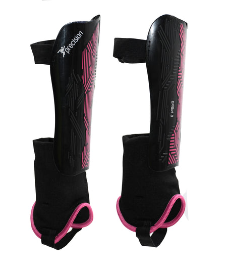 The Precision Training Origin.0 Shin & Ankle Guards are black with pink geometric accents, featuring attached ankle guards and adjustable straps for secure football protection. "Precision" branding is visible on one guard.