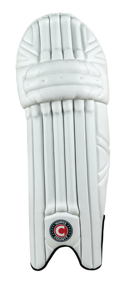 The Hunts County Maximo Batting Pads feature a single white pad with vertical padding, extra wide straps, foam padded instep, rounded top, and the Hunts County logo at the bottom center.