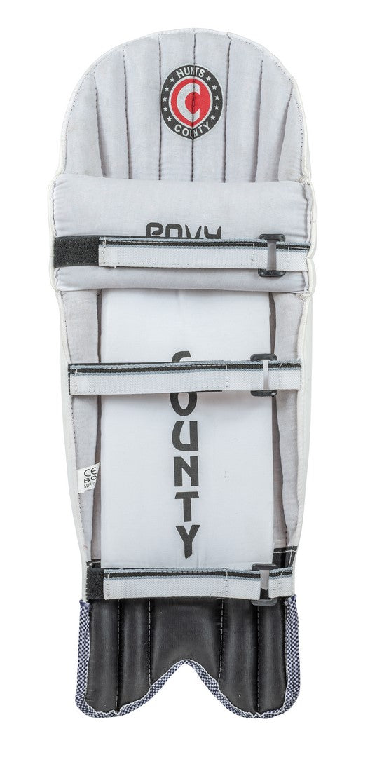 The Hunts County Envy Batting Pads are white and gray with black straps, featuring the Hunts County logo at the top and "COUNTY" printed vertically down the center.