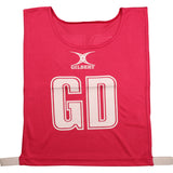 The Gilbert Netball Bibs in pink are made from breathable polyester, featuring bold white GD letters and the Gilbert logo on the front—ideal for your next netball game.