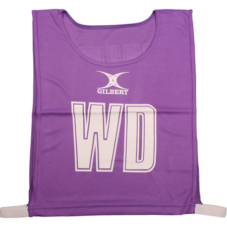 The Gilbert Netball Bibs by Gilbert in purple feature "WD" in bold white letters, made from breathable polyester for comfort—ideal for Wing Defence and perfect as part of a netball bibs set.