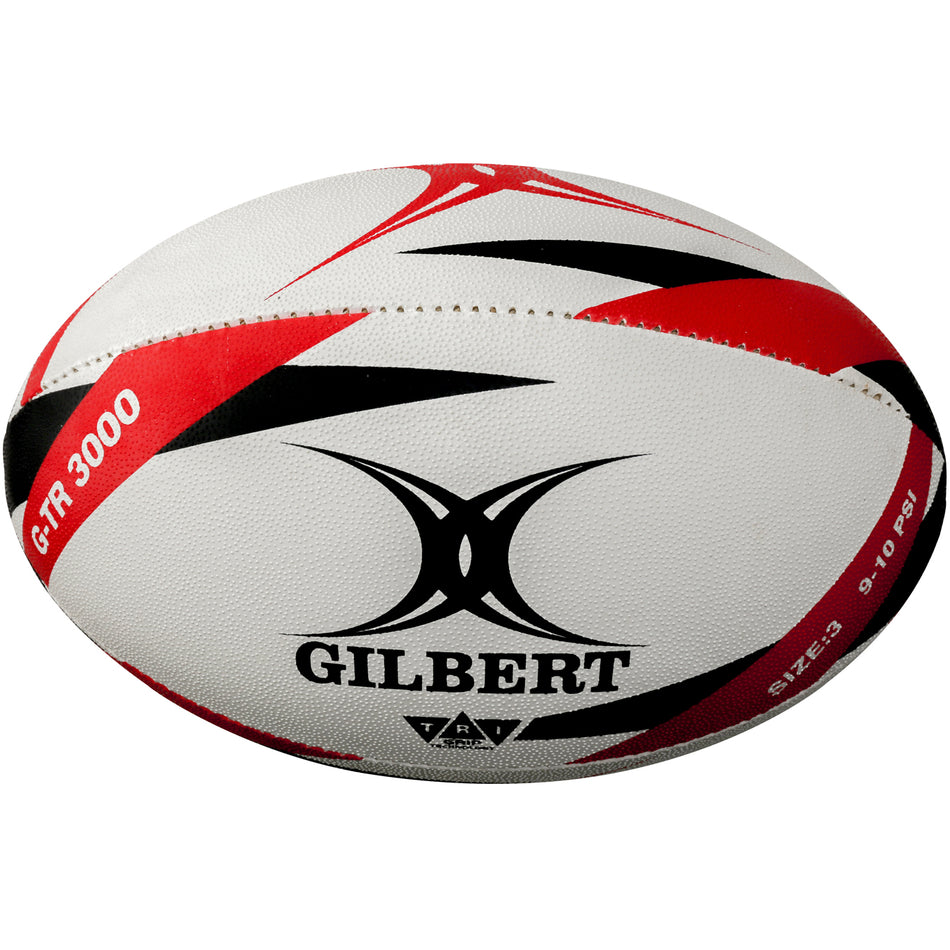 The Gilbert G-TR3000 Training Ball is a white and red rugby ball with black accents, featuring the GILBERT logo, a durable rubber surface, and marked with size and pressure details.