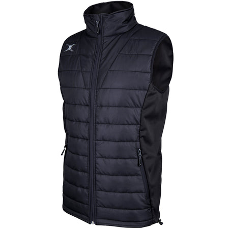 The Gilbert Pro Body Warmer by Gilbert is a black, sleeveless quilted vest featuring a high collar, front zip, two side zip pockets, breathable technical fabric, and a small white chest logo.