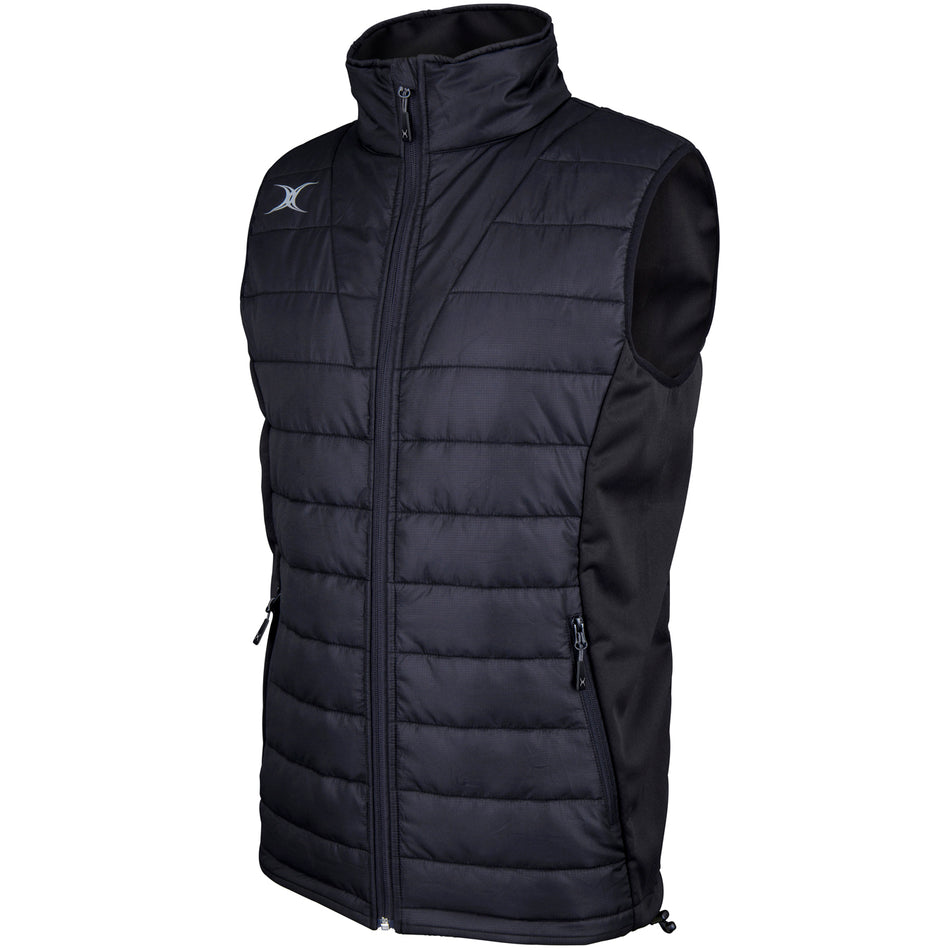 The Gilbert Pro Body Warmer by Gilbert is a black, sleeveless quilted vest featuring a high collar, front zip, two side zip pockets, breathable technical fabric, and a small white chest logo.