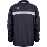 The Gilbert Photon Warm Up Top by Gilbert is a lightweight, long-sleeved training top in Dark Navy/Sky Blue with a light stripe across the chest and shoulders, elastic cuffs, high collar, and a small white logo on the upper left chest.
