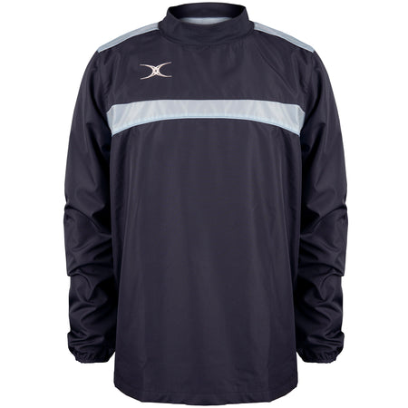 The Gilbert Photon Warm Up Top by Gilbert is a lightweight, long-sleeved training top in Dark Navy/Sky Blue with a light stripe across the chest and shoulders, elastic cuffs, high collar, and a small white logo on the upper left chest.