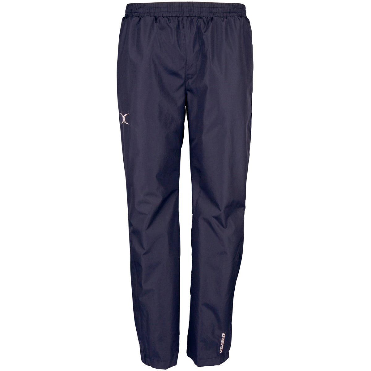 The Gilbert Photon Training Trouser by Gilbert is a navy blue, lightweight over trouser with an elastic waistband, straight legs, breathable water-repellent fabric, and subtle reflective logos on the thigh and lower leg.