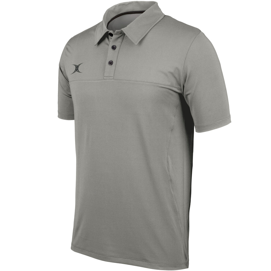 The Gilbert Pro Tech Polo is a grey short-sleeve shirt with a collar, three black buttons, and a small black left-chest logo. Made by Gilbert for off-field wear, it’s shown on a white background.