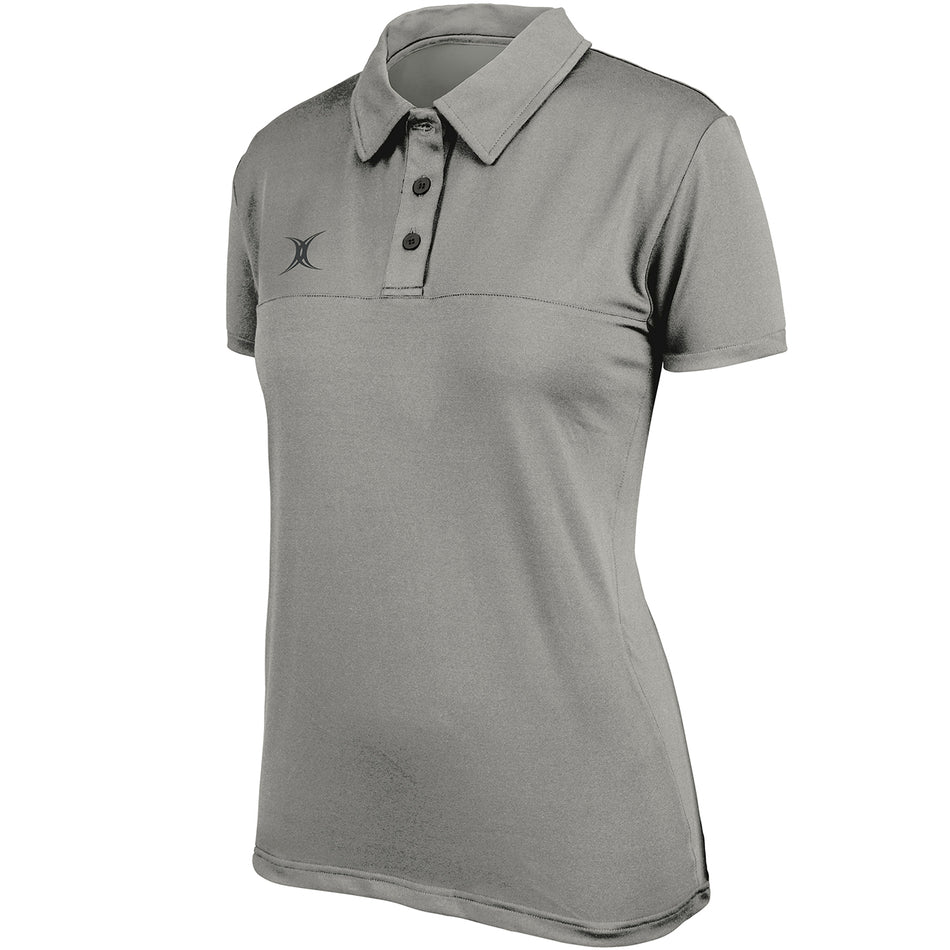 The Gilbert Womens Pro Tech Polo by Gilbert is a black short-sleeve polo for women with a collar, three buttons, moisture-managing fabric, and a small logo on the left chest.