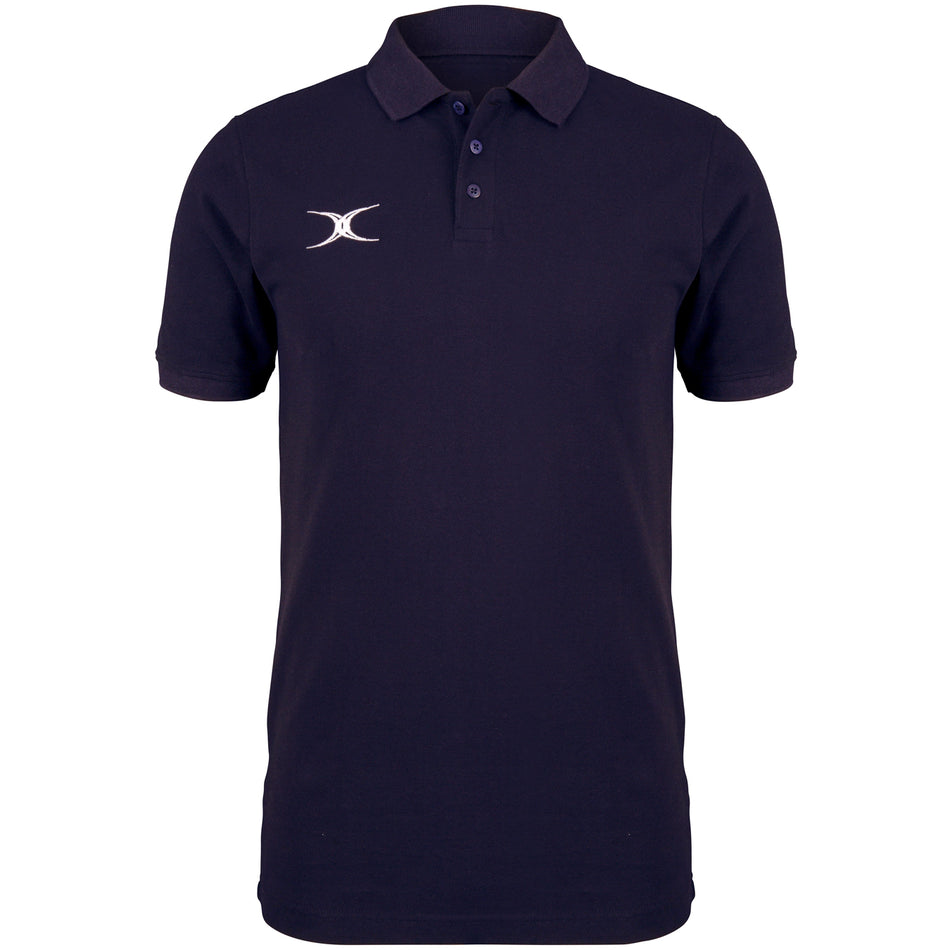 The Gilbert Quest Polo by Gilbert is a plain navy blue organic cotton polo with short sleeves, a three-button placket, and a small white abstract logo on the left chest.