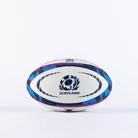 The Gilbert Scotland Replica Rugby Ball by Gilbert features blue and purple patterns, the Scotland rugby logo, and bold "SCOTLAND" lettering—ideal for passionate fans. Displayed on a plain white background.