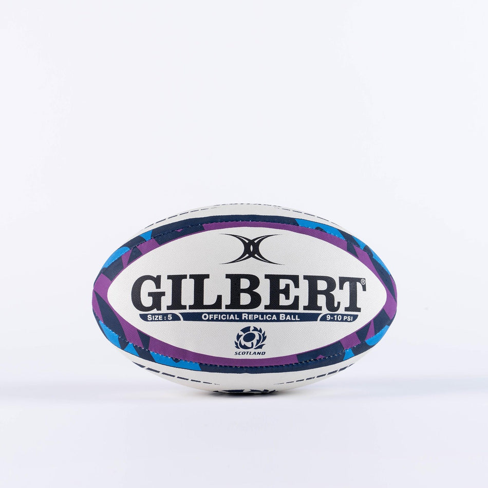 Show your Scotland pride with the Gilbert Scotland Replica Rugby Ball by Gilbert. This white and purple ball features black and blue details, the Scotland Rugby logo, and "Official Replica Ball" text on a plain white background.