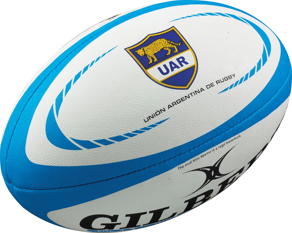 The Gilbert Argentina Replica Rugby Ball is a white and blue ball featuring the Unión Argentina de Rugby emblem and Gilbert logo—perfect for Pumas fans and collectors.