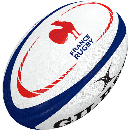 The Gilbert France Replica Rugby Ball features white panels with blue details, red curved lines, and a bold red rooster logo. "FRANCE RUGBY" appears beside the rooster and "GILBERT" is partially visible—perfect for fans of French rugby.