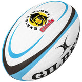The Gilbert Exeter Chiefs Replica Rugby Ball features blue and black accents, the Exeter Chiefs logo, and “Exeter Rugby Chiefs” in black and red—a must-have for fans of the Gallagher Premiership Rugby team.