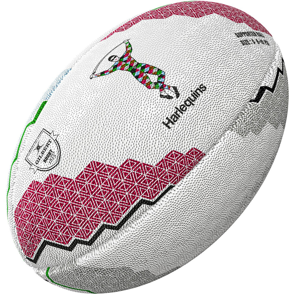 The Gilbert Harlequins Supporter Rugby Ball by Gilbert features red geometric patterns, a diamond-uniformed player graphic, "Harlequins" text, and black zigzags—an ideal piece of memorabilia for any Gallagher Premiership rugby fan.