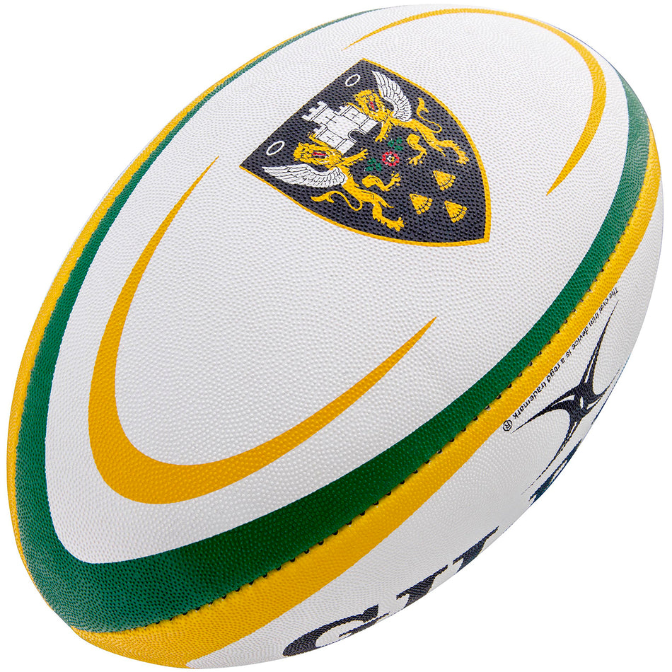 The Gilbert Northampton Saints Replica Rugby Ball features green and yellow curves, club crest with two lions and angel wings, textured grip, branded Gilbert markings, and is perfect for Gallagher Premiership memorabilia collections.