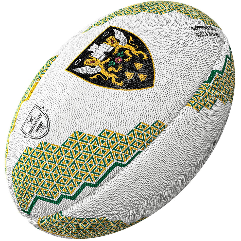 The Gilbert Northampton Saints Supporter Rugby Ball features green and yellow geometric patterns, a black and gold crest with castle and lions, plus the Gallagher Premiership Rugby logo—a must for any fan.