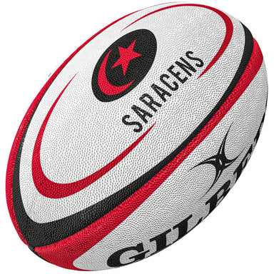 The Gilbert Saracens Replica Rugby Ball is a white ball with red and black accents, featuring the SARACENS name, red star and crescent logo, and partial Gilbert branding—ideal for Gallagher Premiership Rugby fans.