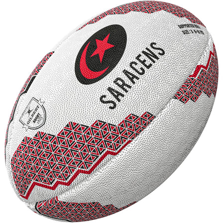 The Gilbert Saracens Supporter Rugby Ball by Gilbert features red and black geometric patterns, the word SARACENS, a red star in a crescent, and logo—ideal rugby memorabilia for any Premiership Rugby fan.