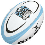 The Gilbert Glasgow Replica Rugby Ball is a white ball with blue accents, featuring the Glasgow Warriors logo and name on one side and the Gilbert logo on another—a great choice for any rugby supporter.