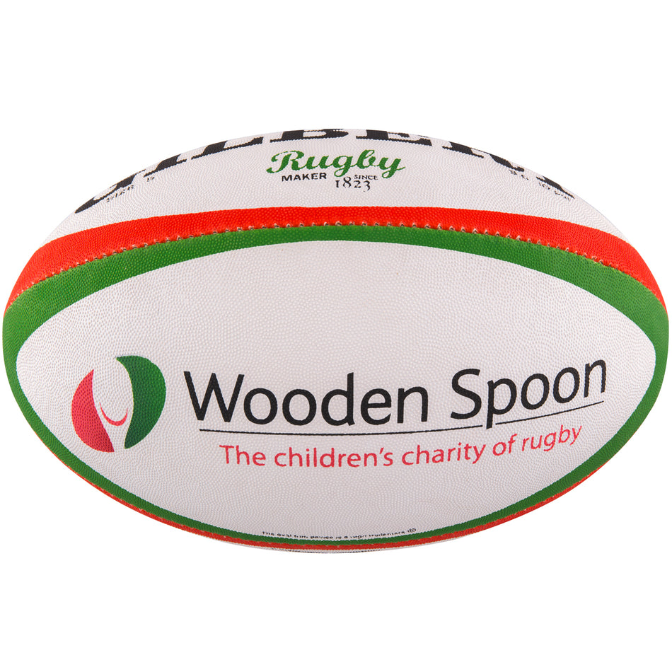 The Gilbert Wooden Spoon Rugby Ball is a white rugby ball with green and red stripes, featuring the Wooden Spoon charity logo and the text: "Wooden Spoon. The children's charity of rugby." Brand: Gilbert.