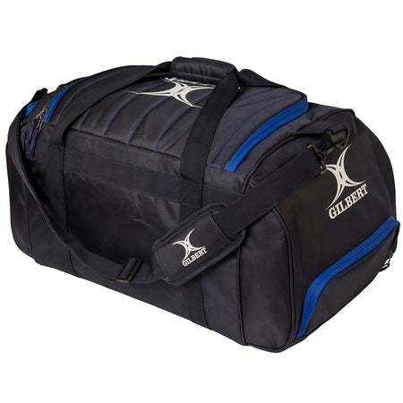 The Gilbert Performance Holdall by Gilbert is a black rugby kit bag featuring blue zippers, padded shoulder strap, handles, and the Gilbert logo printed in white on the side and strap.