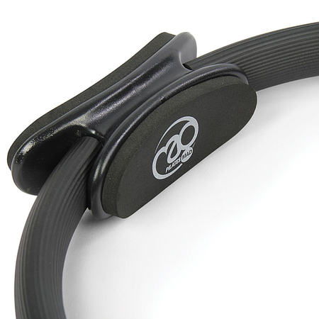 A close-up of the Fitness Mad Pilates Ring - Double Handle in black, with padded side handles and the “Fitness Mad” logo on one pad, set against a plain white background—ideal for toning exercises.