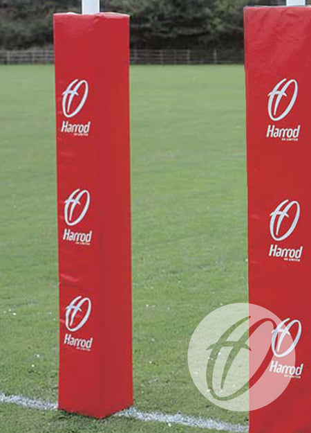 Single Colour Club Rugby Post Protectors, 355mm by Harrod Sport stand on a grassy outdoor field beneath white rugby posts. Trees and a fence blur in the background, highlighting these durable and customisable safety features.