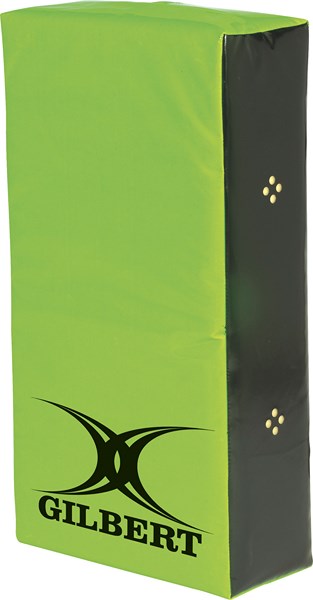 The Gilbert Contact Wedge is a bright green rectangular hit shield for junior rugby training, with black sides, four yellow side dots, and "GILBERT" plus the black logo printed on the front.