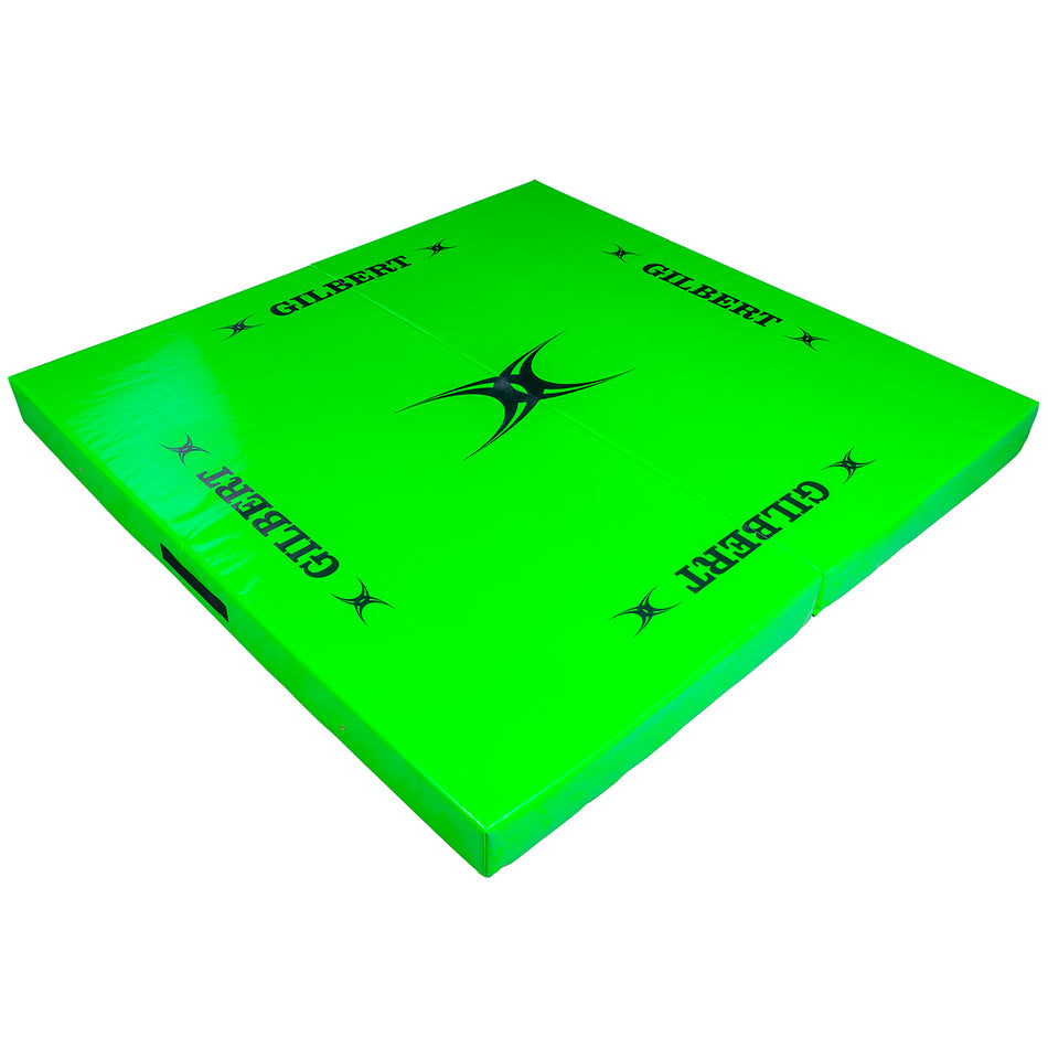 The Gilbert Tackle Mat is a large, bright green high-density foam mat for contact training, featuring "GILBERT" in black on each side and a central black star design, shown on a white background.
