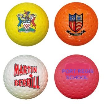 Four Readers Custom Printed Hockey Balls: yellow with multicolored crest, orange with shield emblem, white with "Martin Berrill" in red, and pink with "Port Regis School" in blue.