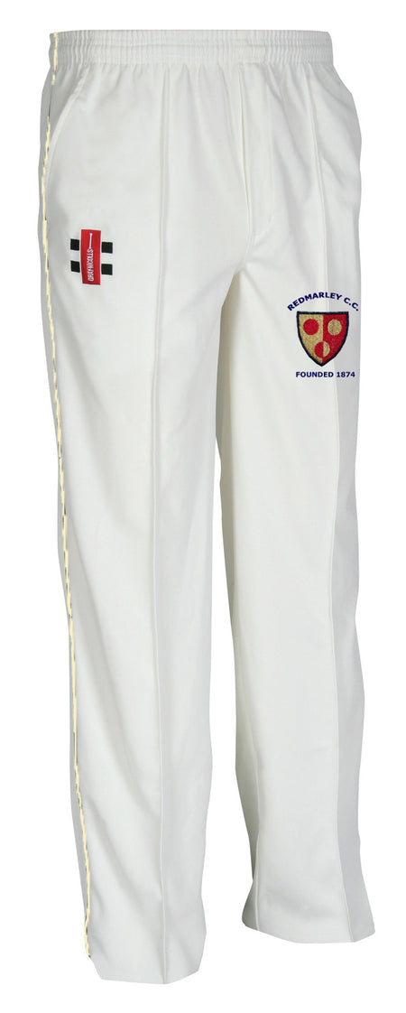 The Gray Nicolls Redmarley CC Junior Matrix V2 Cricket Trouser is white with a tapered fit, an elastic waistband, a red and black logo on the left thigh, and an embroidered club crest with text on the right thigh.