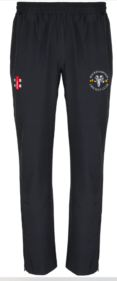 The Gray Nicolls Rockhampton CC Velocity Track Trouser - Junior features an elastic waistband, the England cricket logo on the right thigh, and a Brockhampton Cricket Club sheep emblem on the left. Ideal for cricket training.